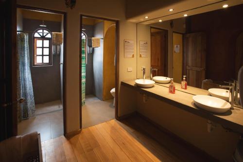 a bathroom with two sinks and a large mirror at Llullu Llama Mountain Lodge in Hacienda Provincia