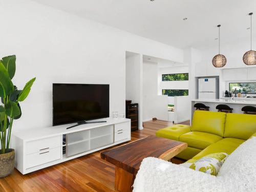 a living room with a couch and a tv at Soho Beach House - Apollo Bay in Apollo Bay