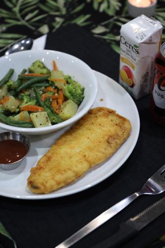a table with a plate of food with a plate of vegetables at The Raz in Harrismith