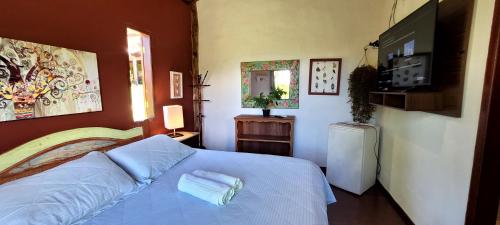 una camera da letto con un letto e asciugamani di Pousada da Lua a Delfinópolis