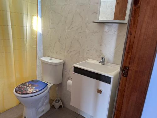 a bathroom with a toilet and a sink at Hyepy in Punta Del Diablo