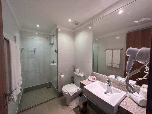 a bathroom with a sink and a toilet and a mirror at Suíte Vista Azul - Frente para Pedra Azul in Pedra Azul