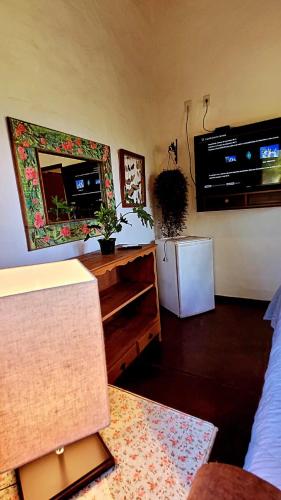 a living room with a refrigerator and a mirror at Pousada da Lua in Delfinópolis