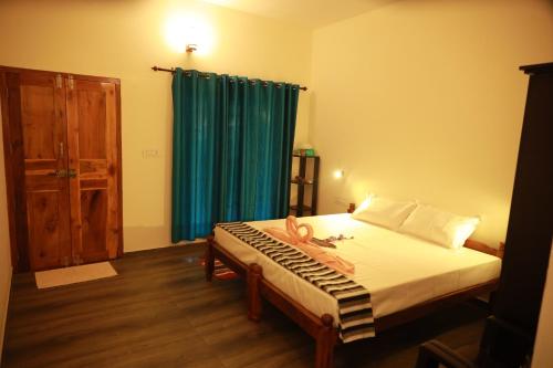 ein Schlafzimmer mit einem Bett mit einem blauen Vorhang in der Unterkunft Marari Sophy Villa in Mararikulam