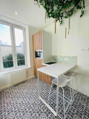 une cuisine avec une table blanche et une fenêtre dans l'établissement Nancy Gare - Appartement TOUT ÉQUIPÉ & cosy, à Nancy