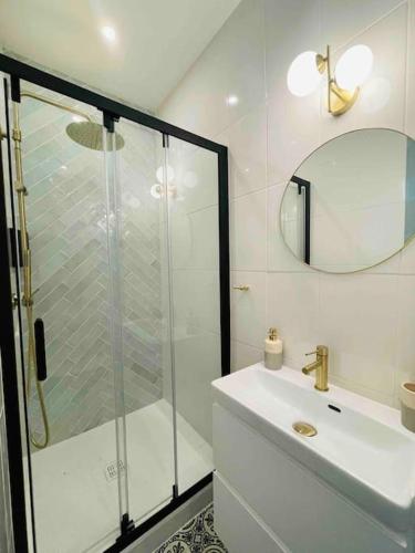 une salle de bain blanche avec une douche et un lavabo dans l'établissement Nancy Gare - Appartement TOUT ÉQUIPÉ & cosy, à Nancy