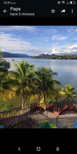 a screenshot of a picture of a lake with palm trees at Hotel y Hostal Mi Reino Represa Prado Tolima in Prado