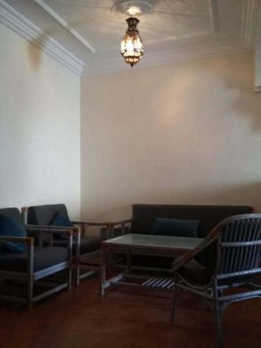une chambre avec des chaises, une table et un lustre dans l'établissement rihhana house, à Agadir