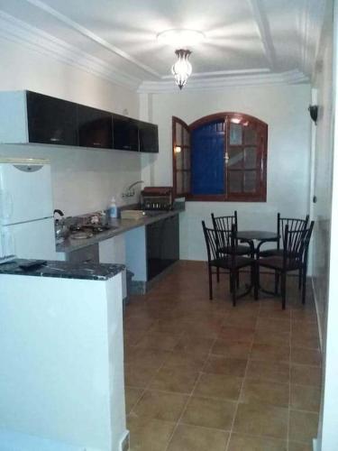 a kitchen with a table and chairs in a room at rihhana house in Agadir