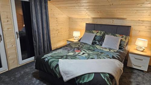 een slaapkamer met een bed met een houten muur bij Domek Madzi - Misiowa Polanka in Marciszów