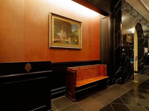 a room with a bench and a painting on the wall at Hotel Monterey Kyoto in Kyoto