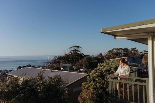 a man standing on a balcony looking at the ocean at Vitamin Sea at Skenes Creek Amazing Ocean Views in Skenes Creek