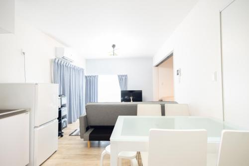 a white kitchen with white tables and white chairs at 大久保駅から４分、貸切、韓国ダウン至近、新宿/歌舞伎町に徒歩圏内 、단독사용민박 in Tokyo