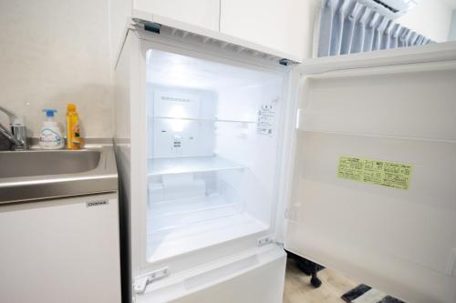 an empty refrigerator with its door open next to a sink at 大久保駅から４分、貸切、韓国ダウン至近、新宿/歌舞伎町に徒歩圏内 、단독사용민박 in Tokyo