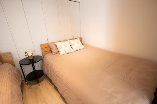 a small bedroom with two beds and a table at 大久保駅から４分、貸切、韓国ダウン至近、新宿/歌舞伎町に徒歩圏内 、단독사용민박 in Tokyo