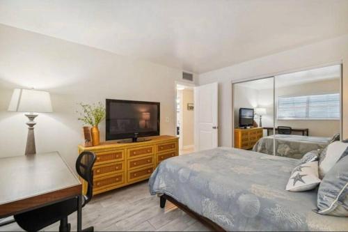 een slaapkamer met een bed en een flatscreen-tv bij Vanderbilt Mercado Villa Oasis. in Naples