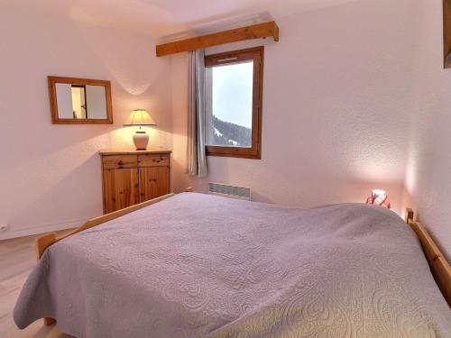 une chambre avec un grand lit et une fenêtre dans l'établissement Duplex Calme 6/7 Pers - Proche Commerces, Ski aux Pieds, Balcon Nord, TV, Non-Fumeur - FR-1-182-114, à Méribel
