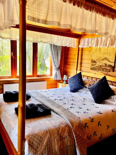 a bedroom with a bed in a room with windows at Secluded Rustic Cabin - A Digital Detox Paradise. in York