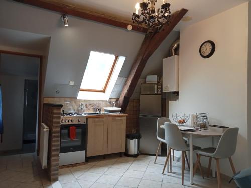 een keuken met een tafel en stoelen en een klok aan de muur bij Splendide Moulins in Moulins