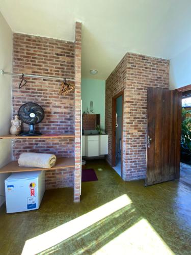 - un salon avec un mur en briques et une porte dans l'établissement Escarpas do Caraça, à Catas Altas