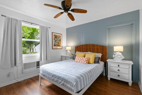 棕櫚灘海岸的住宿－Sunshine shores boutique apartments，一间卧室配有一张床和吊扇