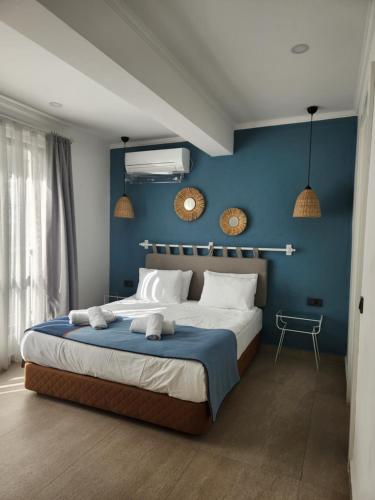 a bedroom with a large bed with blue walls at Park Hotel Rooms & Apart in Antalya