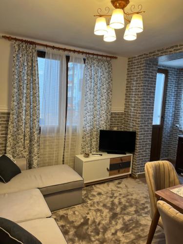 a living room with a couch and a tv at Dream Apartment in Bansko
