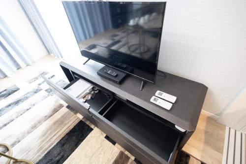 a flat screen tv on a table in a living room at 大久保駅から４分、貸切、韓国ダウン至近、新宿/歌舞伎町に徒歩圏内 、단독사용민박 in Tokyo
