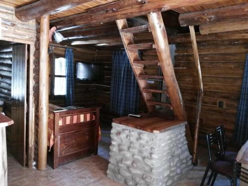 a living room with a staircase in a log cabin at BienAltura in Uspallata