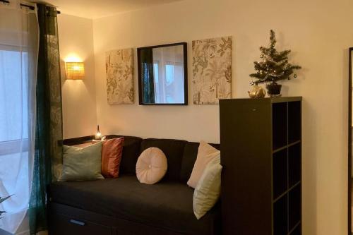 - un salon avec un canapé noir et des oreillers dans l'établissement Cozy’Wood, à Brest