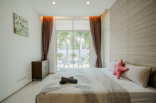 Un dormitorio con una cama grande con dos animales de peluche. en City Beach Cha-am Pool Villa en Cha Am
