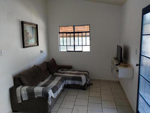 a living room with a couch and a window at Bangalô Alto da Pedreira in Socorro