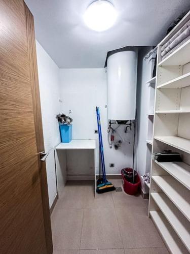 a room with a closet with a broom and a shelf at Piso Camariñas Playa de Area in Camariñas