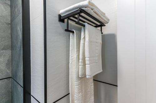 een handdoekenrek in de badkamer met witte handdoeken bij VR LATINA APARTMENTS in Madrid
