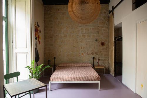 a bed in a room with a brick wall at Magma Home - Rooms & Roof in Naples
