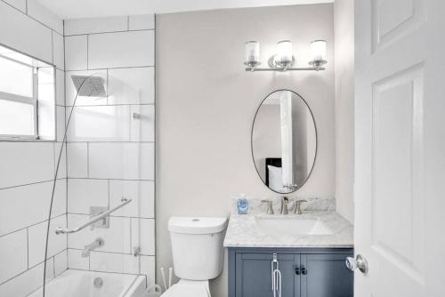 a white bathroom with a sink and a mirror at Pionciana Getaway 1BR Apartment Near FLL Airport in Fort Lauderdale