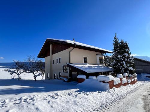 a barn with snow on the ground in front of it at Ferienhaus Praschberg in Niederndorferberg