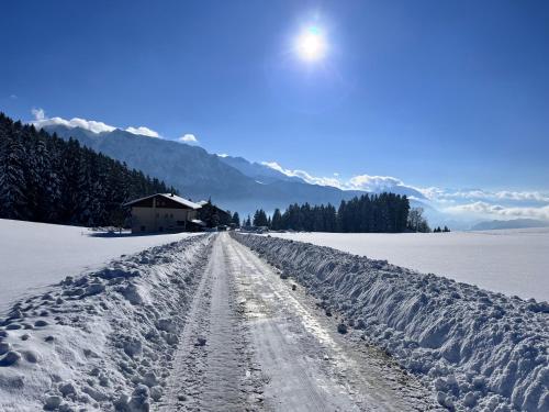 a snow covered road with a house in the background at Ferienhaus Praschberg in Niederndorferberg