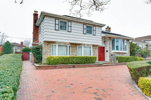 a house with a red door and a brick driveway at Cozy Valley Stream Studio, 20 Mi to Times Square! in Laurelton
