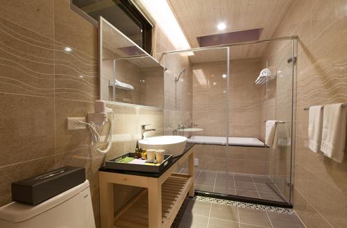a bathroom with a sink and a glass shower at 花蓮晨風星語民宿Sun Star B&B in Jian