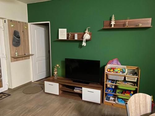 a living room with a flat screen tv on a table at Kökszi Beach Nyaralóházak in Balatonszabadi