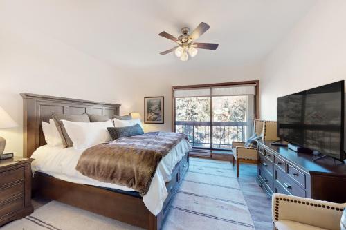 a bedroom with a bed and a flat screen tv at SunRiver E102 in Avon
