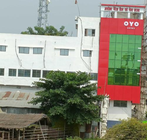 a white and red building with a tree in front of it at OYO Flagship Ashoka Guest House in Bihta