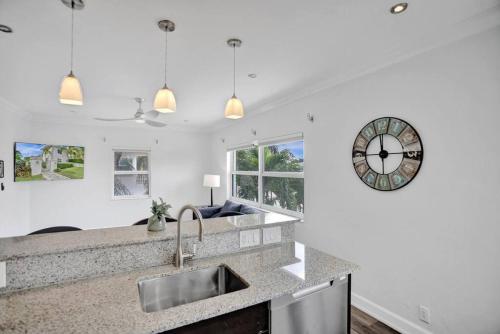 a kitchen with a sink and a clock on the wall at Beach Isles Modern 1BR Apartment in Fort Lauderdale in Fort Lauderdale