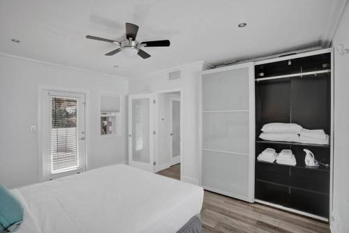 1 dormitorio blanco con 1 cama y ventilador de techo en Beach Isles Modern 1BR Apartment in Fort Lauderdale, en Fort Lauderdale