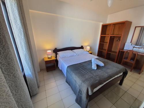 Un dormitorio con una cama con un osito de peluche. en Hotel Sulmar, en Tramandaí