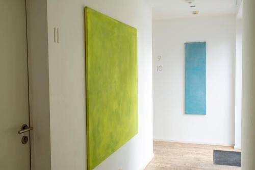 a green painting on a wall next to a door at Hotel Tafelfreuden in Oldenburg