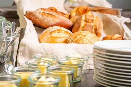 a table topped with a basket of pastries and plates at Hotel Tafelfreuden in Oldenburg