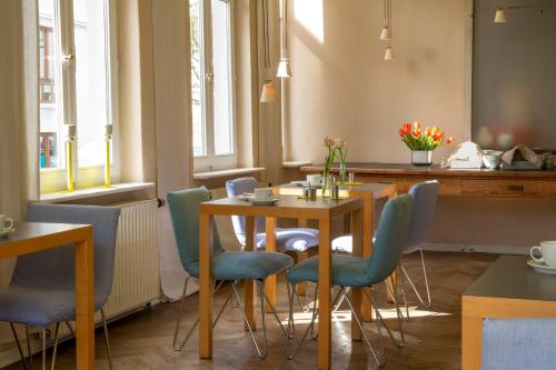 a dining room with a table and blue chairs at Hotel Tafelfreuden in Oldenburg