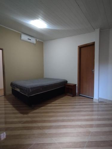 a bedroom with a bed in a room with a door at Casa no Centro de Prado in Prado